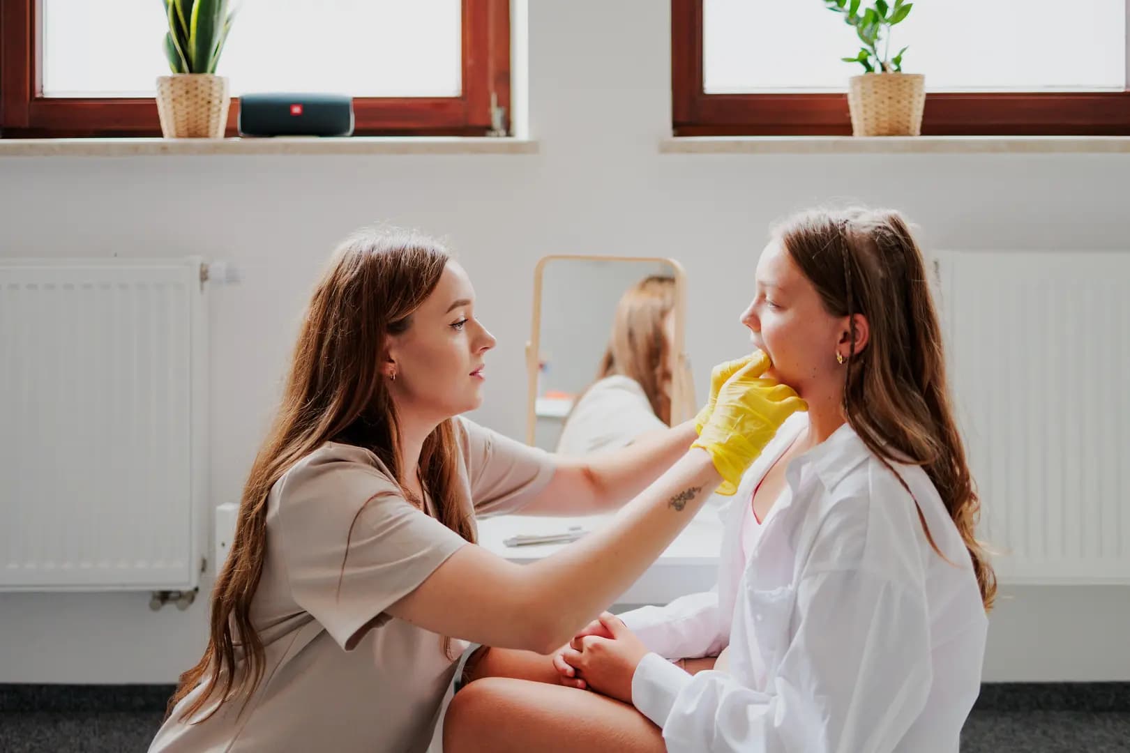 Logopeda prowadzący zajęcia z dzieckiem obok lustra